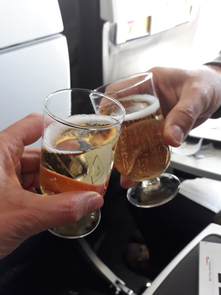champagne glasses clinking on the plane for a weekend away without the kids