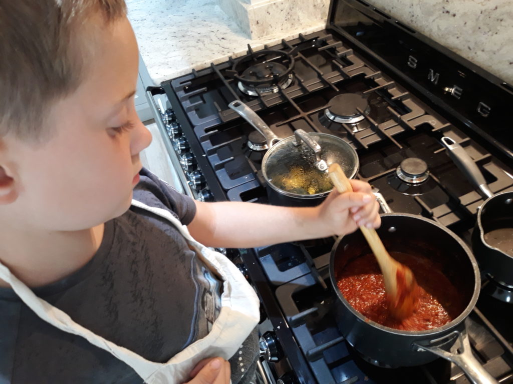 7 year old engrossed in learning how to cook curry