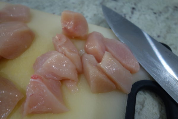 chopping up chicken breast for homemade chicken nuggets