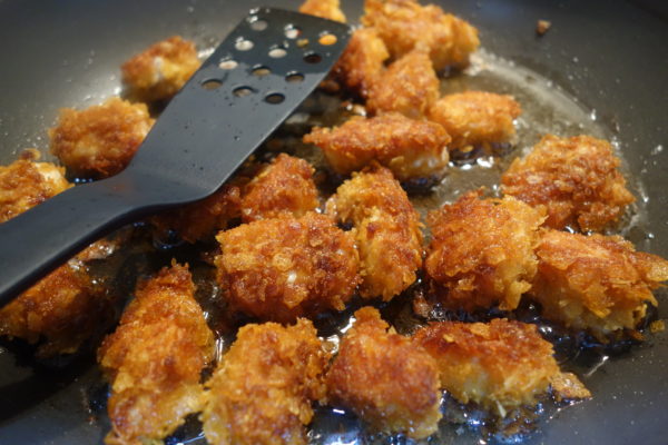 homemade chicken nuggets being cooked in frying pan