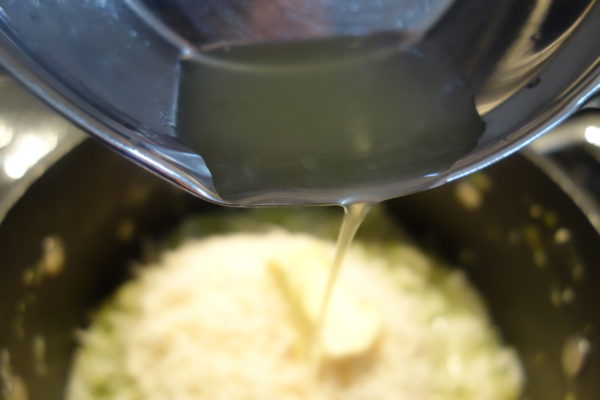 pouring lemon juice into the Courgette Risotto